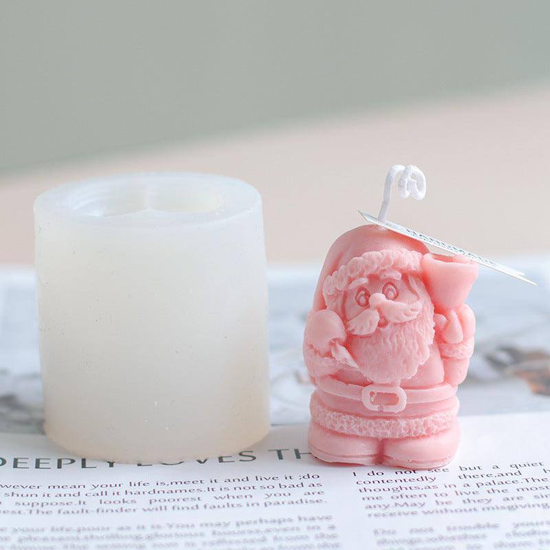 a candle and a pink figurine sitting on top of a newspaper