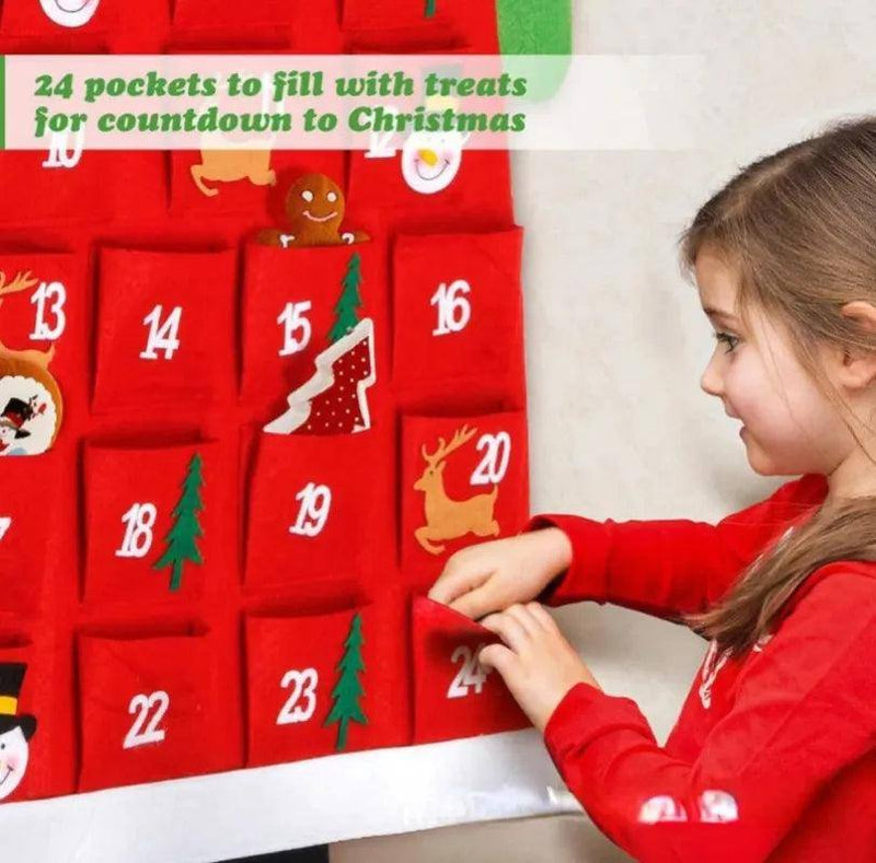 a young girl is putting a christmas calendar on a wall