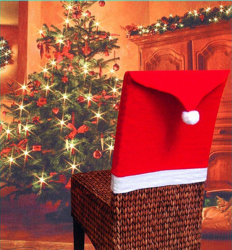 a santa hat sitting on top of a wicker chair next to a christmas tree