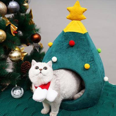 a white cat sitting in a christmas tree shaped bed